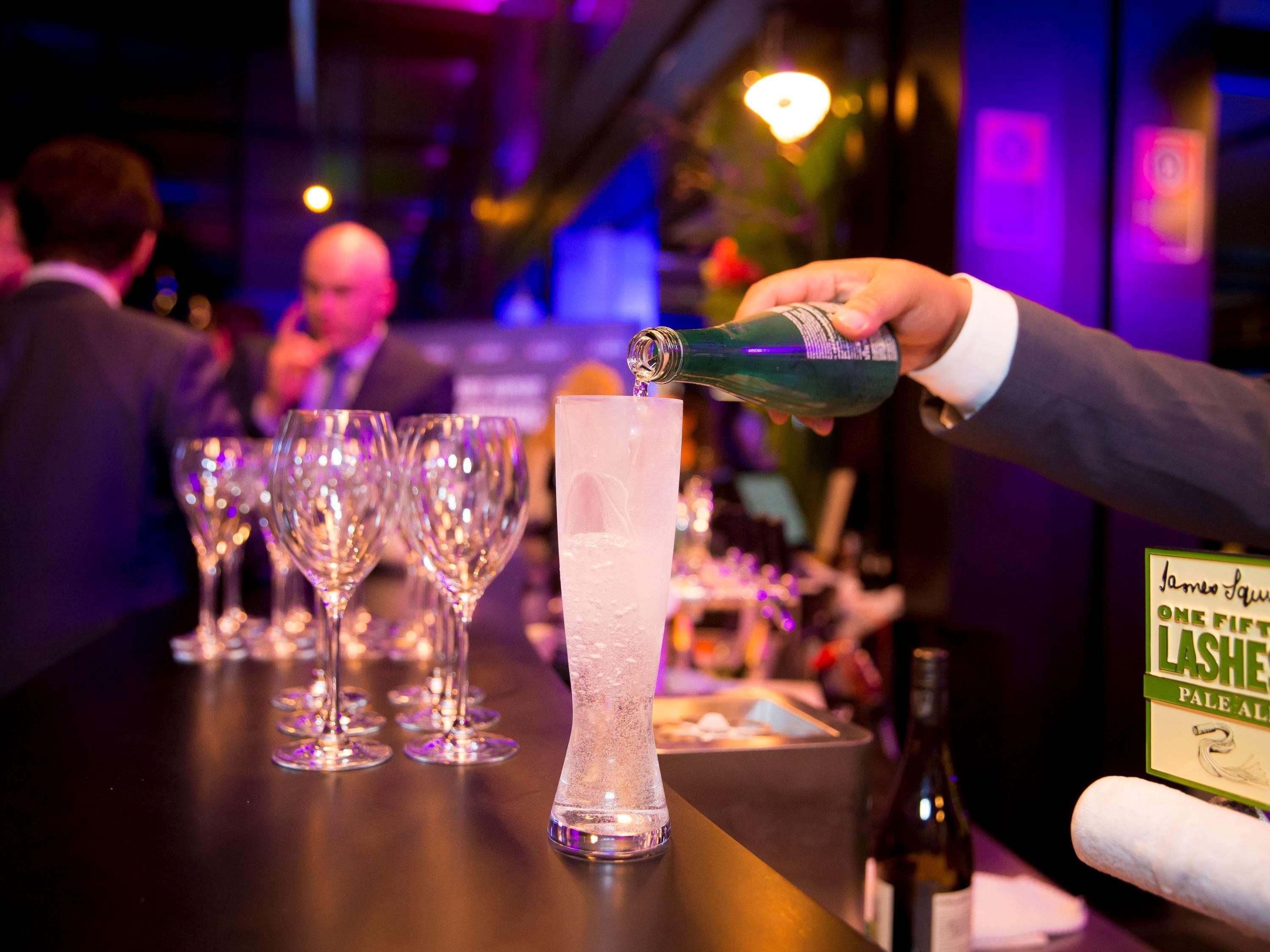 Hotel Pullman Sydney Airport Zewnętrze zdjęcie A bartender pouring champagne